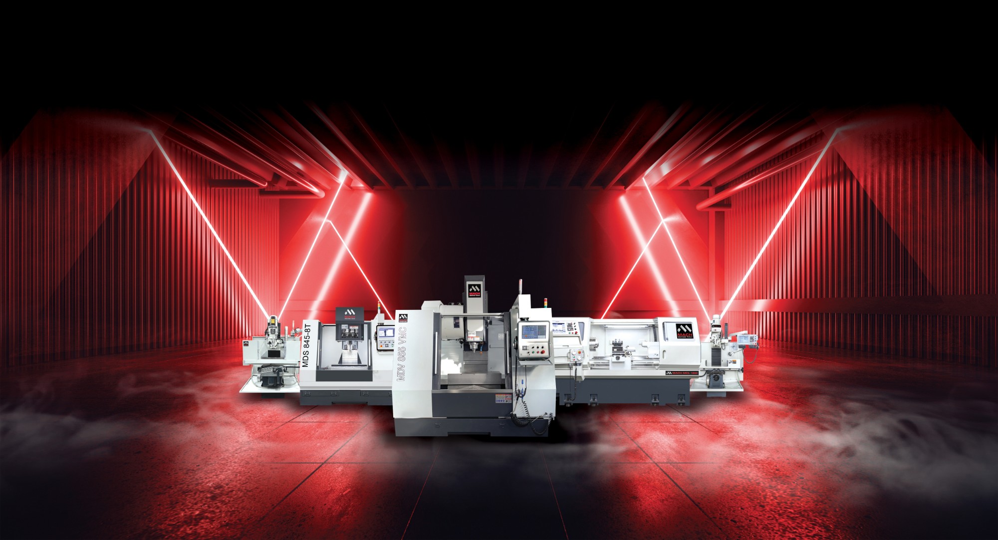 A line-up of MACH CNC machining centers and a lathe, including the MDV 1160 VMC, lit in red